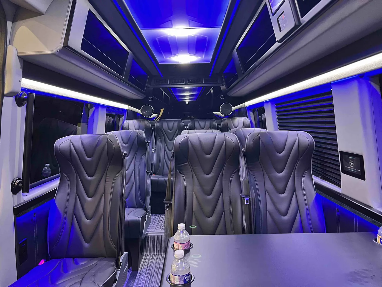 14 Passenger 2024 Mercedes-Benz Executive Sprinter interior with captain's chairs, passenger tables and cup holders for minibus rental