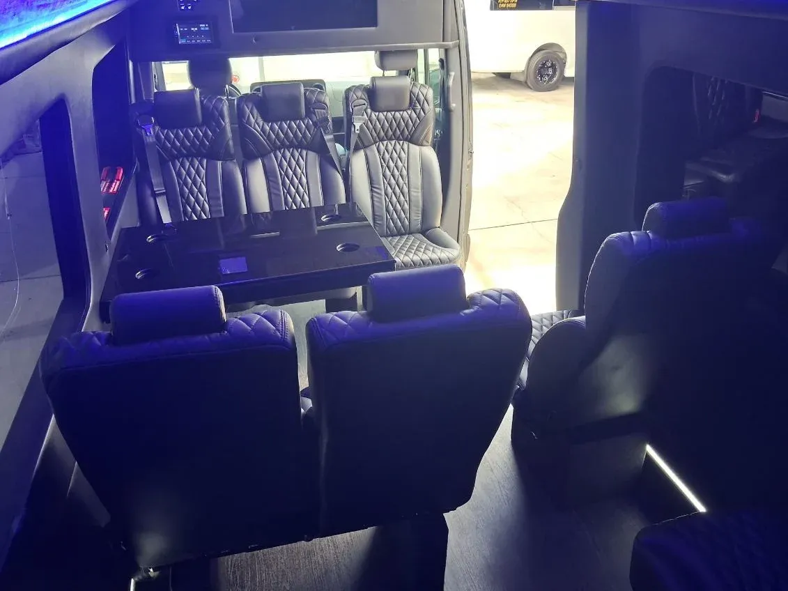 Black Luxury Sprinter Shuttle Van interior with captain's chairs, passenger tables and LED accent lighting, photo 3 for minibus rental