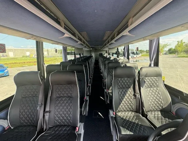 40 Passenger Charter Bus interior with window shades and overhead parcel racks for charter bus rental