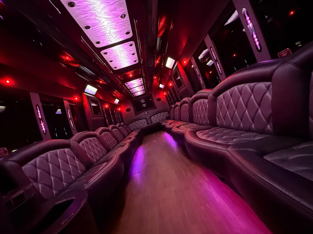 Freightliner Party Bus Freightliner Party Bus interior with perimeter lounge seating, LED ceiling lighting and wood-look flooring for party bus rental