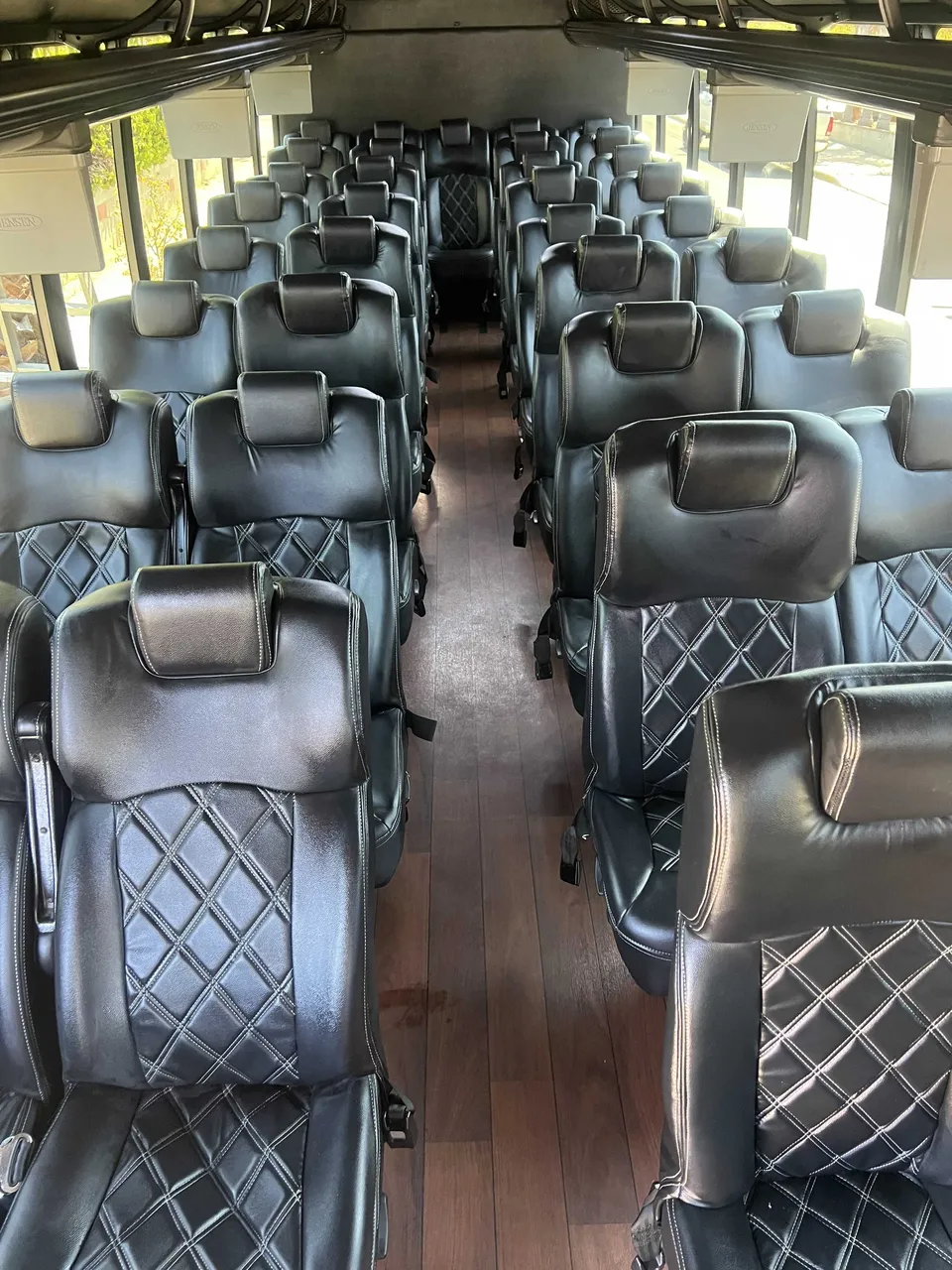Executive Mini-Coach interior with airline-style seats and wood-look flooring for minibus rental
