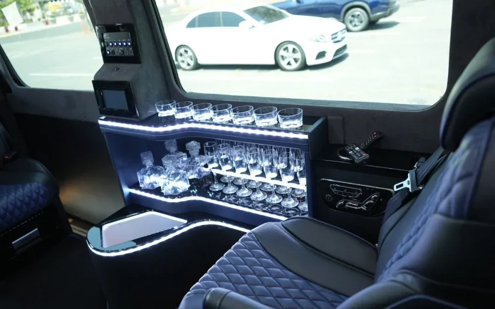8 Passenger Executive Sprinter Shuttle Van interior with captain's chairs, LED accent lighting and bar area for minibus rental