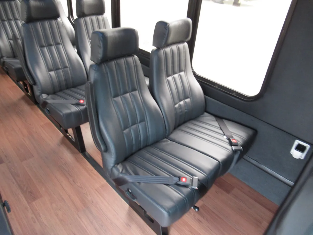 Ford F600 Executive VIP Shuttle Bus (32 Passengers) Ford F600 Executive VIP Shuttle Bus (32 Passengers) interior with wood-look flooring and passenger seat belts for minibus rental