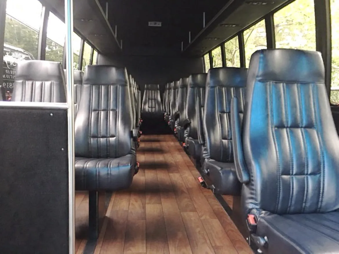 28 Passenger Ford F550 Executive VIP Mini Coach interior with wood-look flooring and passenger seat belts for minibus rental