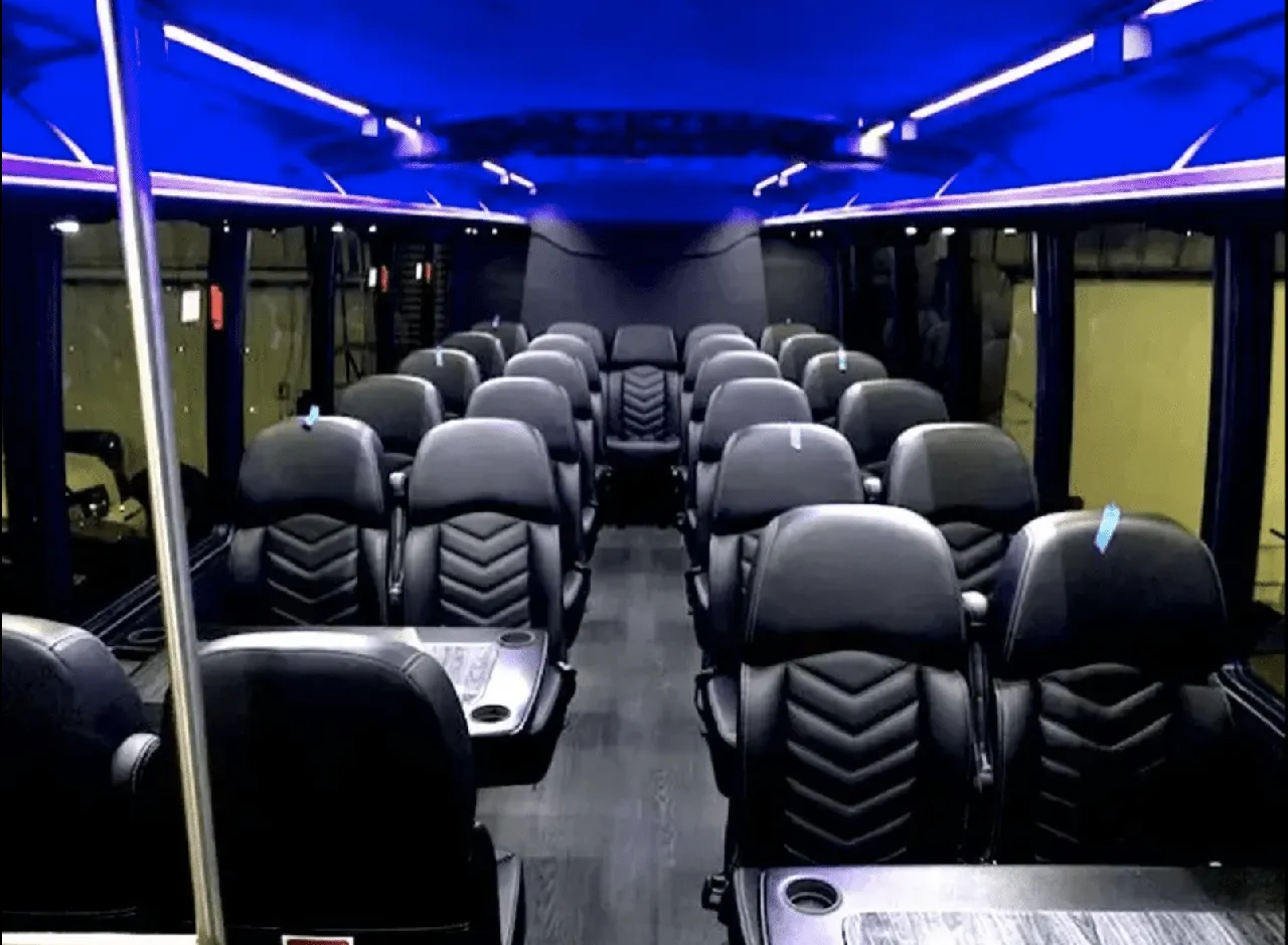 Ford Mini-Coach interior with passenger tables, cup holders and LED ceiling lighting for minibus rental