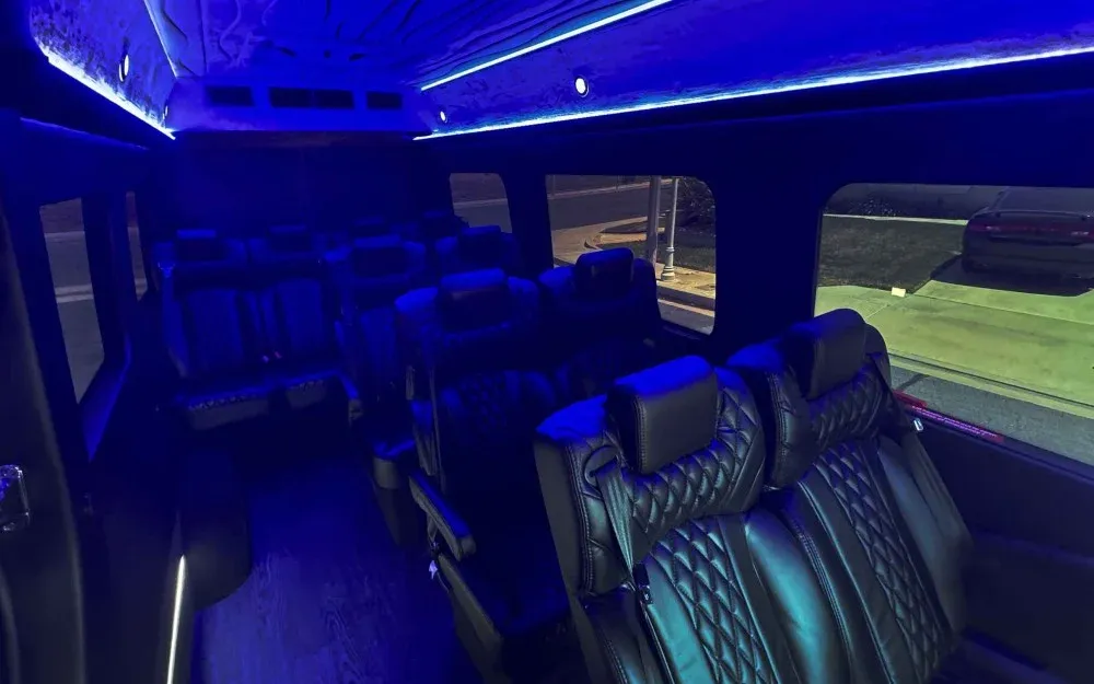 Gray Luxury Sprinter Shuttle Van interior with captain's chairs, LED accent lighting and LED ceiling lighting for minibus rental