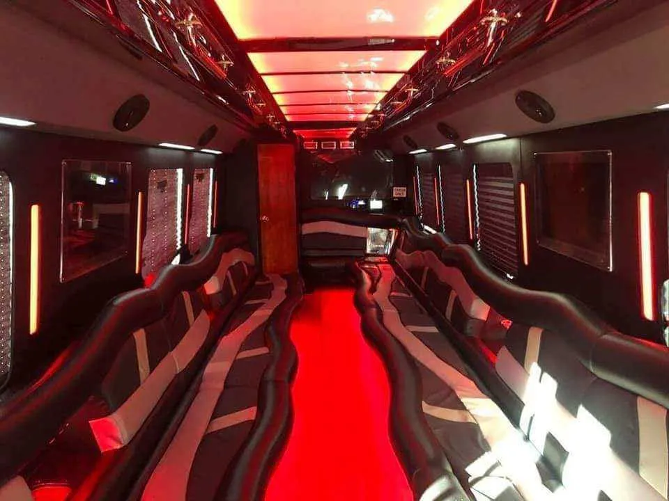 Limousine Bus interior with perimeter lounge seating, LED accent lighting and LED ceiling lighting for party bus rental