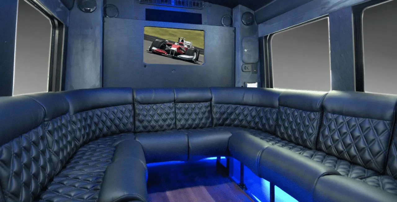 Limousine Coach interior with perimeter lounge seating, sofa-style seating and LED accent lighting for party bus rental