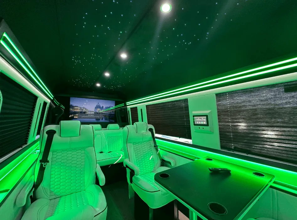 Luxury Mercedes-Benz Sprinter interior with captain's chairs, passenger tables and window shades for minibus rental