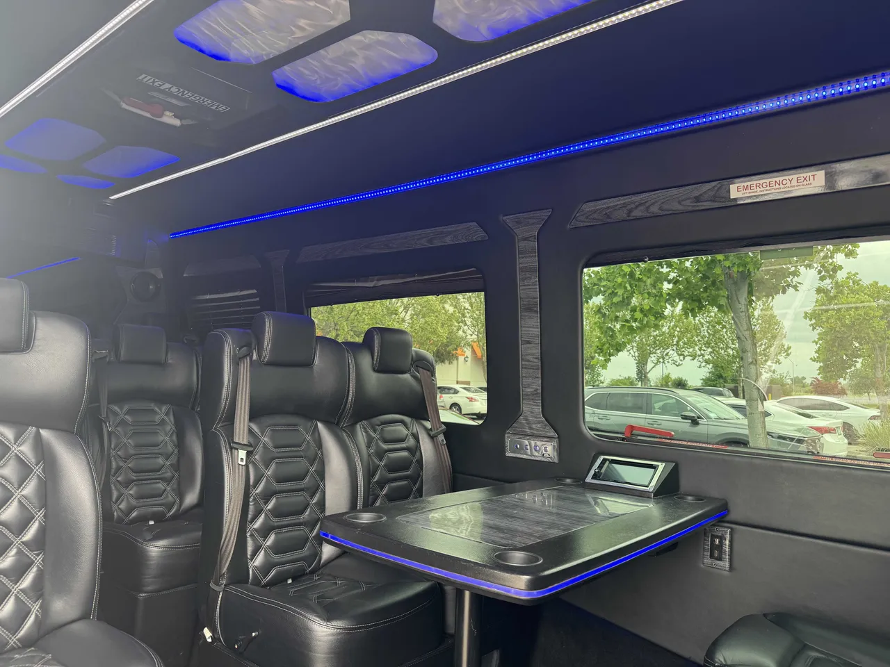 Mercedes-Benz Executive Sprinter interior with passenger tables, cup holders and LED accent lighting for minibus rental