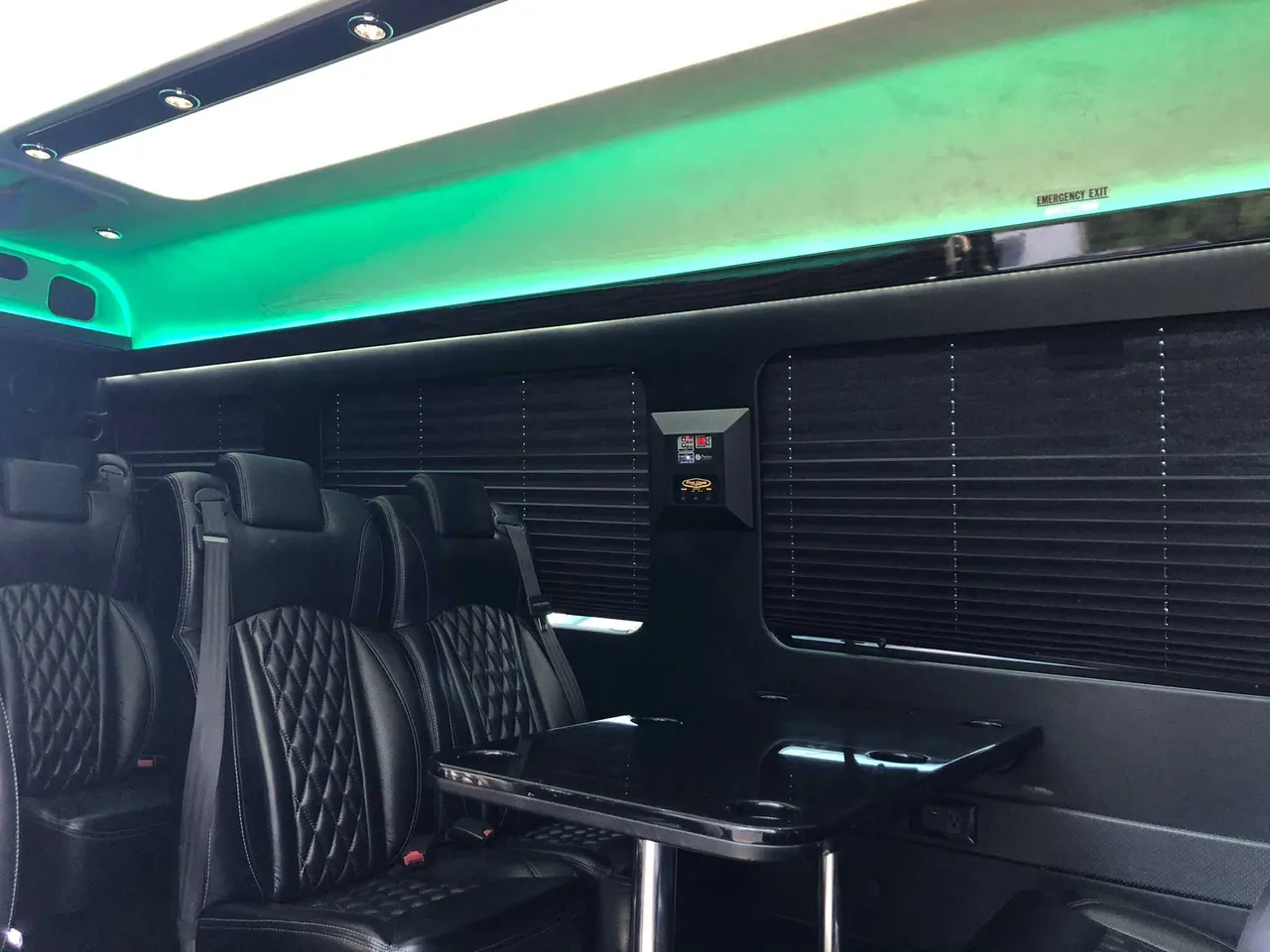 Mercedes-Benz Executive Sprinter interior with captain's chairs, passenger tables and window shades for minibus rental