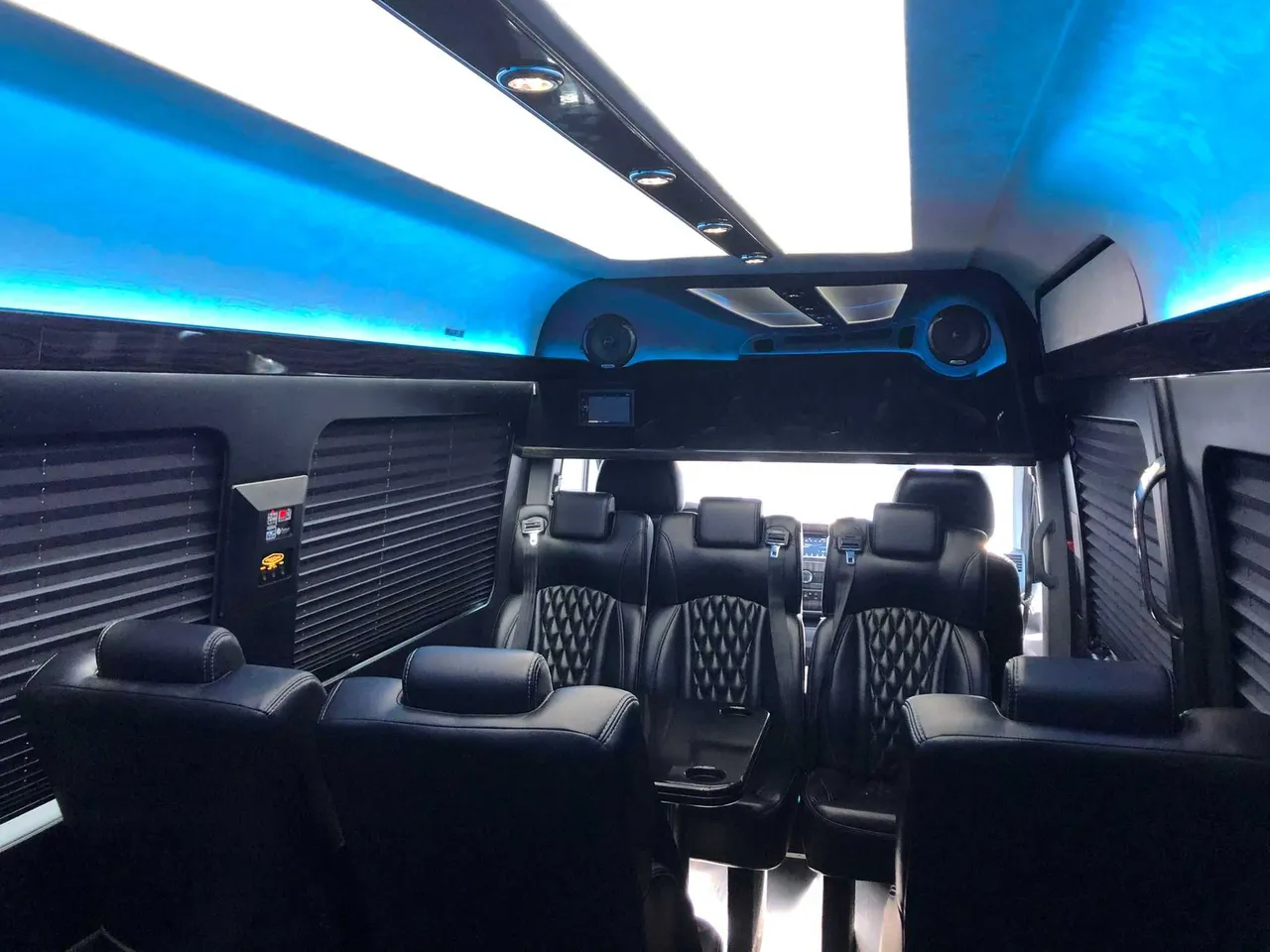 Mercedes Executive Sprinter interior with captain's chairs, window shades and LED ceiling lighting for minibus rental