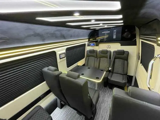 Mercedes-Benz Executive Sprinter interior with passenger tables, window shades and LED accent lighting for minibus rental