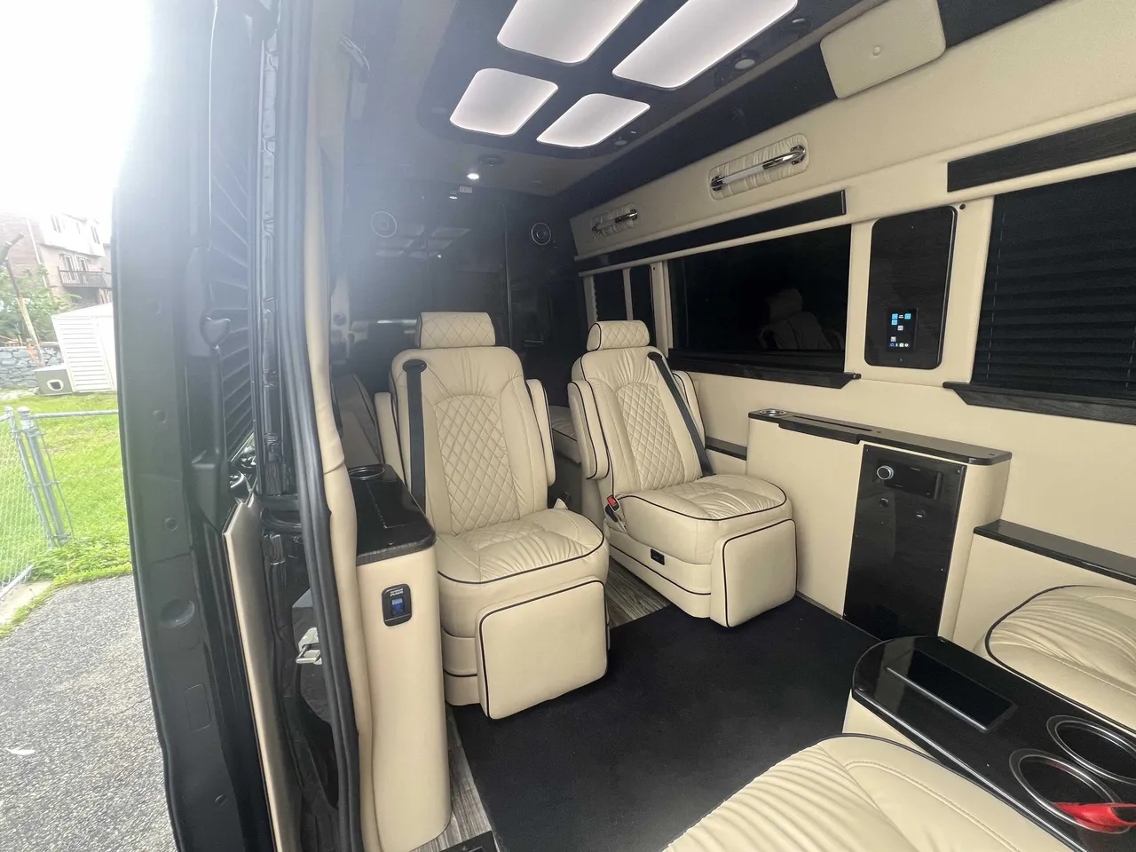 Mercedes-Benz Executive Sprinter interior with captain's chairs, window shades and LED ceiling lighting for minibus rental
