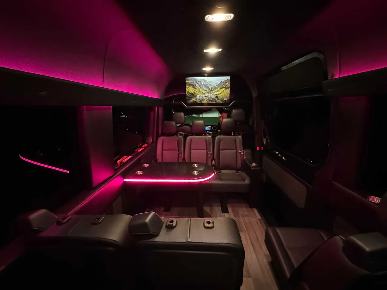 Mercedes-Benz Executive Sprinter Mercedes-Benz Executive Sprinter interior with passenger tables, LED accent lighting and wood-look flooring for party bus rental
