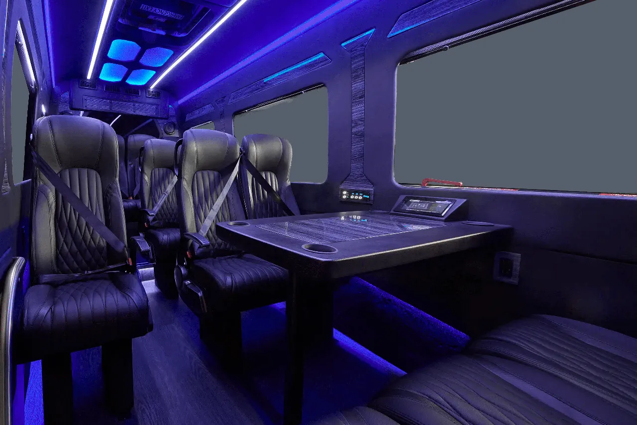 Mercedes-Benz Executive Sprinter Mercedes-Benz Executive Sprinter interior with captain's chairs, passenger tables and LED accent lighting for minibus rental