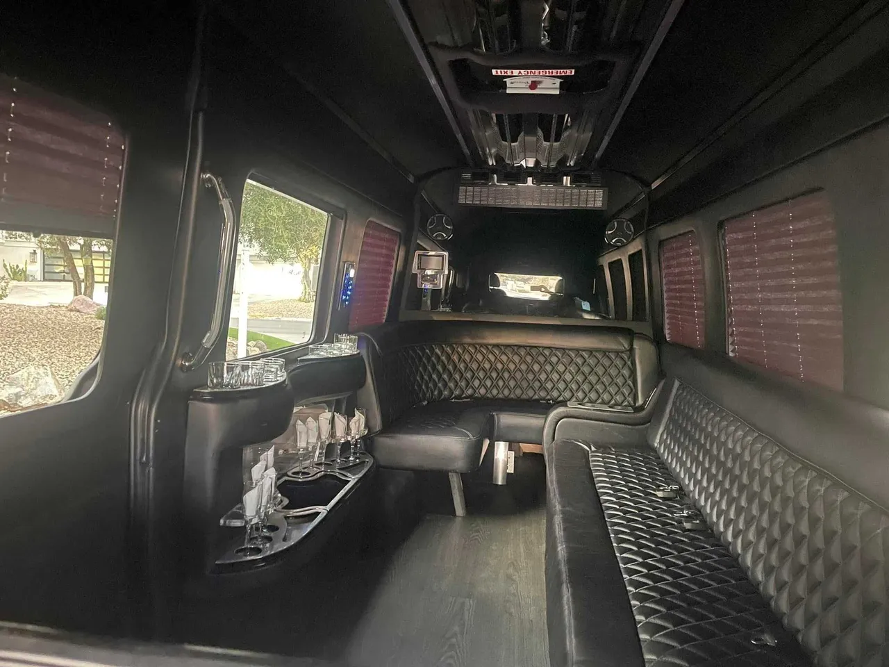 Mercedes-Benz Limousine Sprinter interior with perimeter lounge seating, window shades and bar area for party bus rental