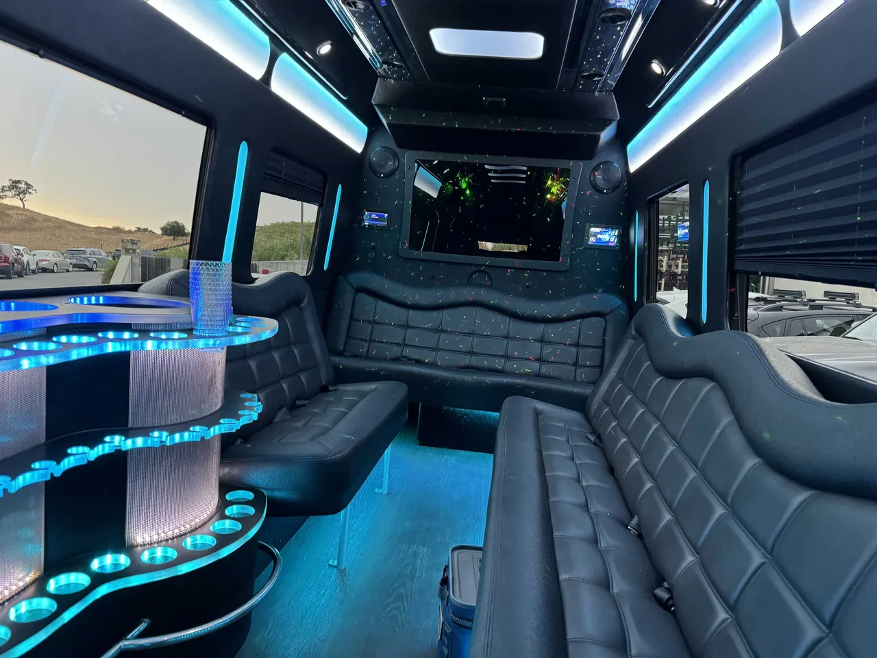 Mercedes-Benz Party Bus interior with perimeter lounge seating, window shades and LED accent lighting for party bus rental