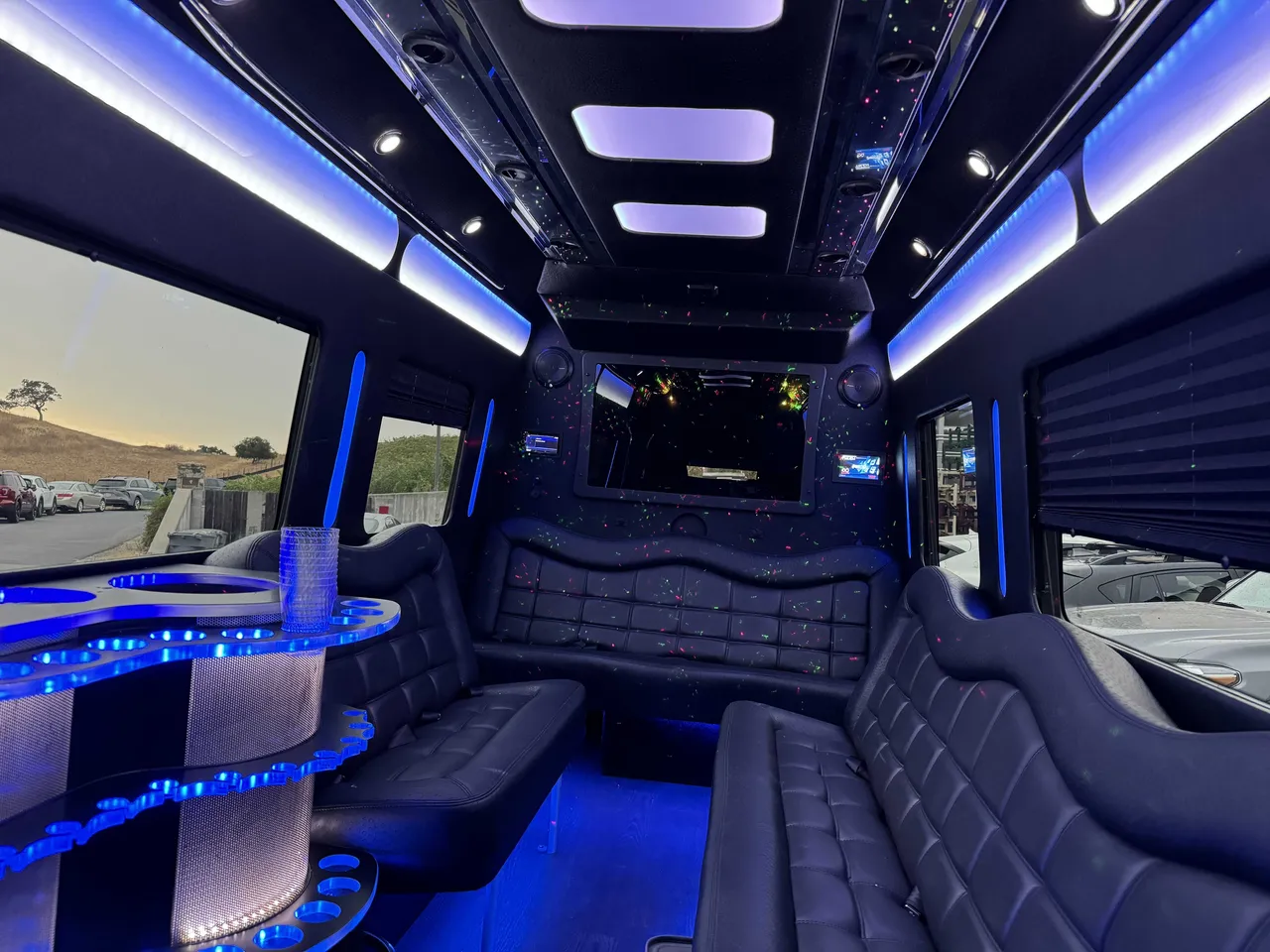 Mercedes-Benz Party Bus interior with perimeter lounge seating, window shades and LED accent lighting, photo 5 for party bus rental