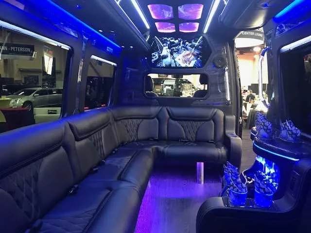 Mercedes-Benz Party Bus interior with sofa-style seating, LED accent lighting and LED ceiling lighting for party bus rental
