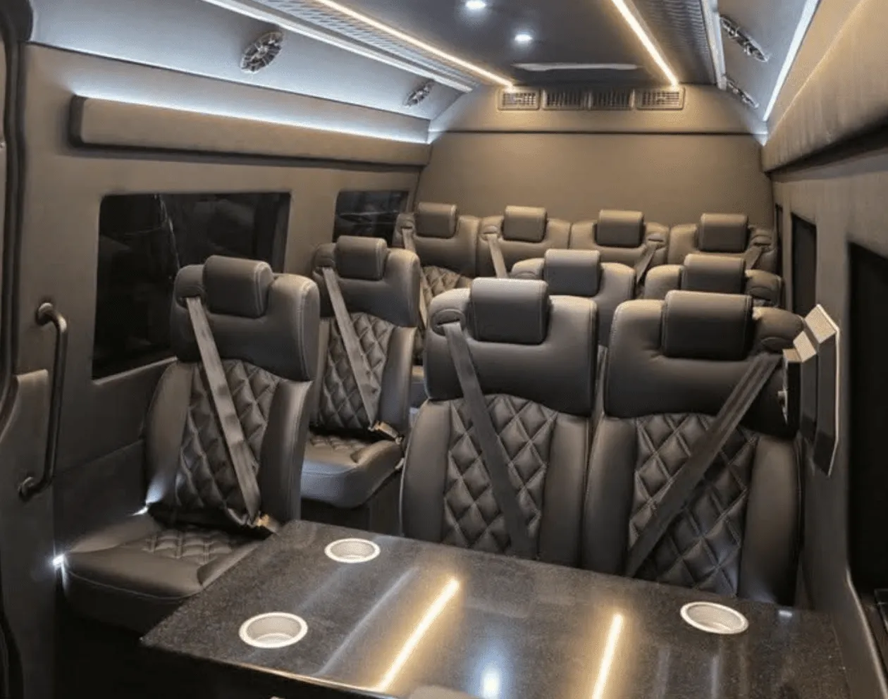 Mercedes-Benz Sprinter Executive interior with captain's chairs, passenger tables and cup holders for minibus rental
