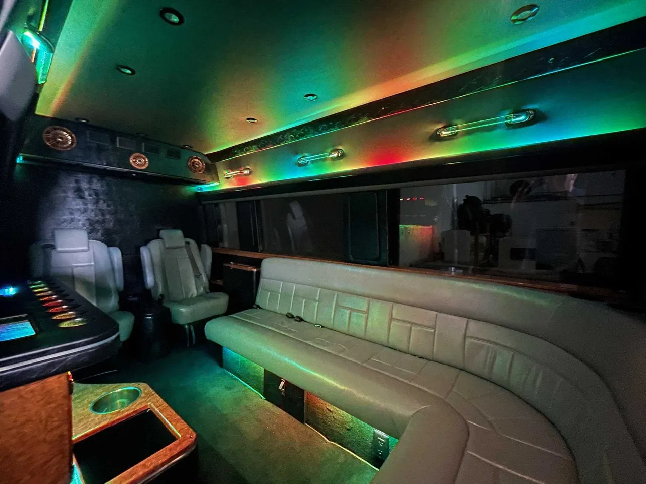 Mercedes-Benz Sprinter Limousine interior with sofa-style seating, captain's chairs and LED accent lighting for party bus rental