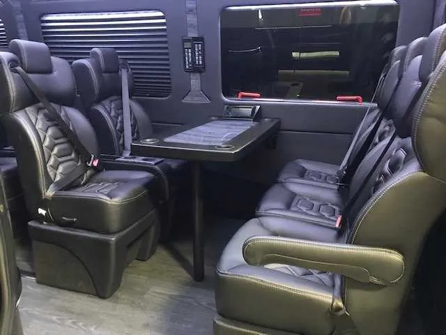 11 Passenger Mercedes-Benz Sprinter Luxury interior with captain's chairs, passenger tables and window shades for minibus rental
