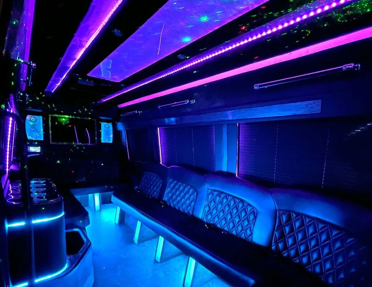 Mercedes-Benz Sprinter XL interior with perimeter lounge seating, window shades and LED accent lighting for party bus rental