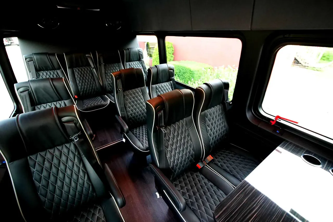 Mercedes-Benz Executive Sprinter Mercedes-Benz Executive Sprinter interior with captain's chairs, passenger tables and wood-look flooring for minibus rental
