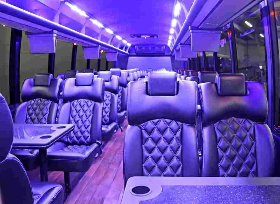 40 Passenger Mini Coach 40 Passenger Mini Coach interior with passenger tables, cup holders and LED ceiling lighting for minibus rental
