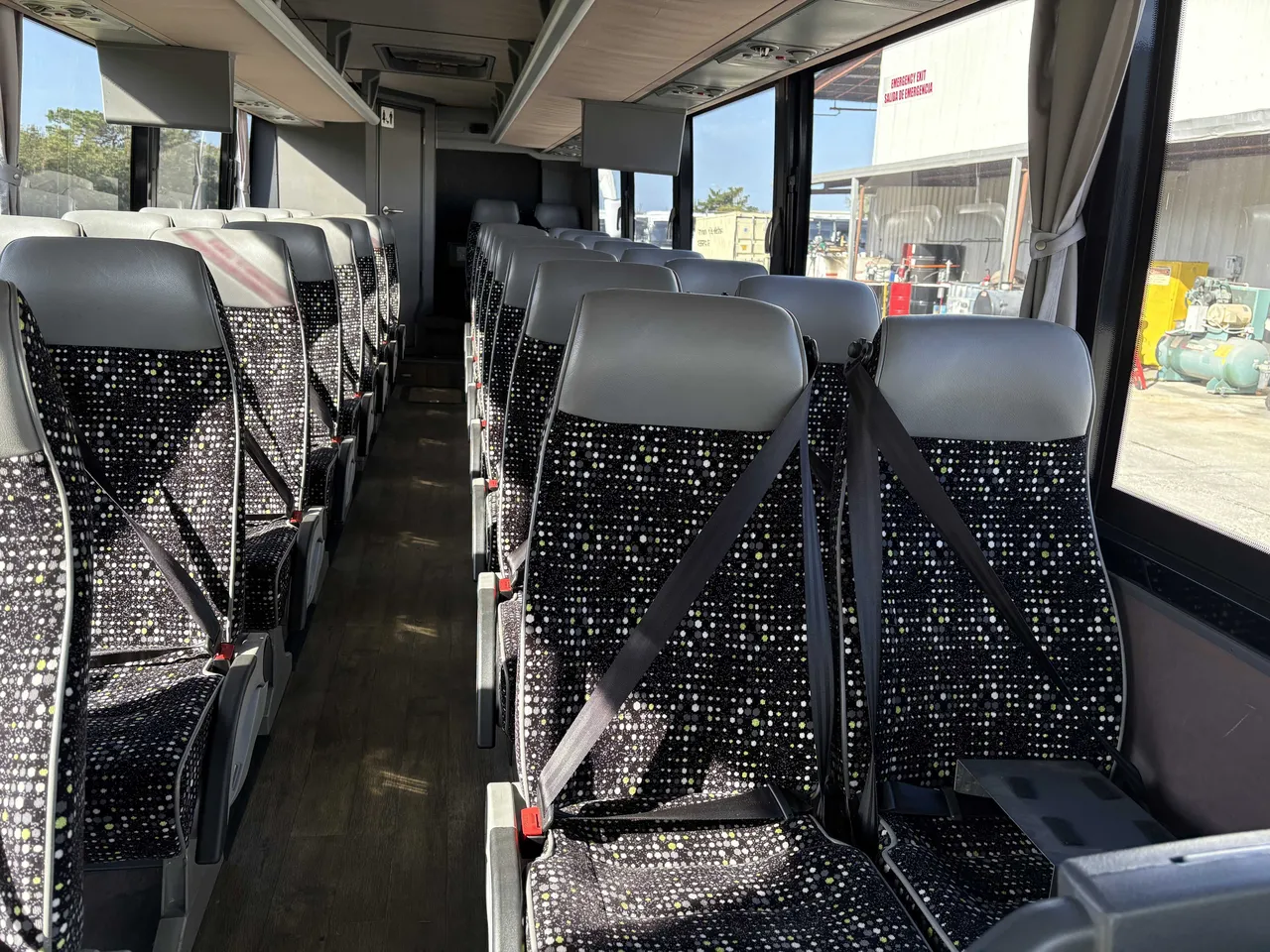 24 Passenger Mini Coach interior with window shades, wood-look flooring and passenger seat belts for minibus rental