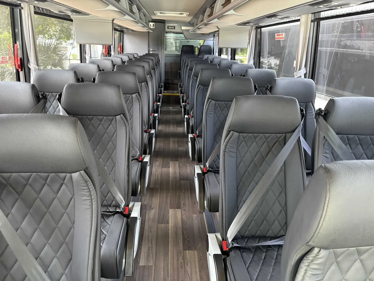 40 Passenger Mini Coach interior with airline-style seats, wood-look flooring and TV screens for minibus rental