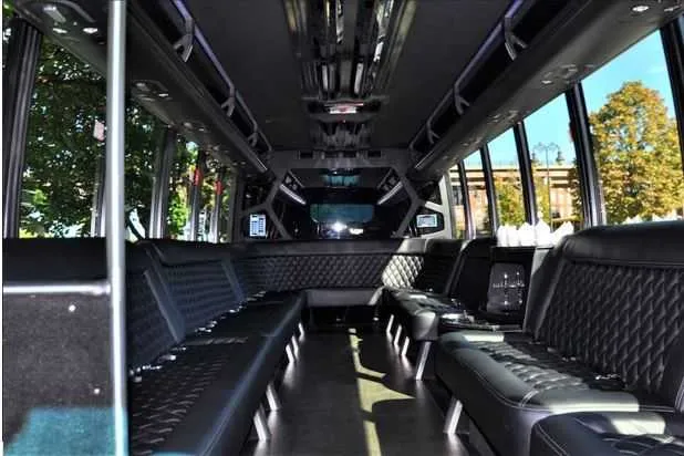 Mini Coach Limousine Bus Mini Coach Limousine Bus interior with perimeter lounge seating and dance pole for party bus rental
