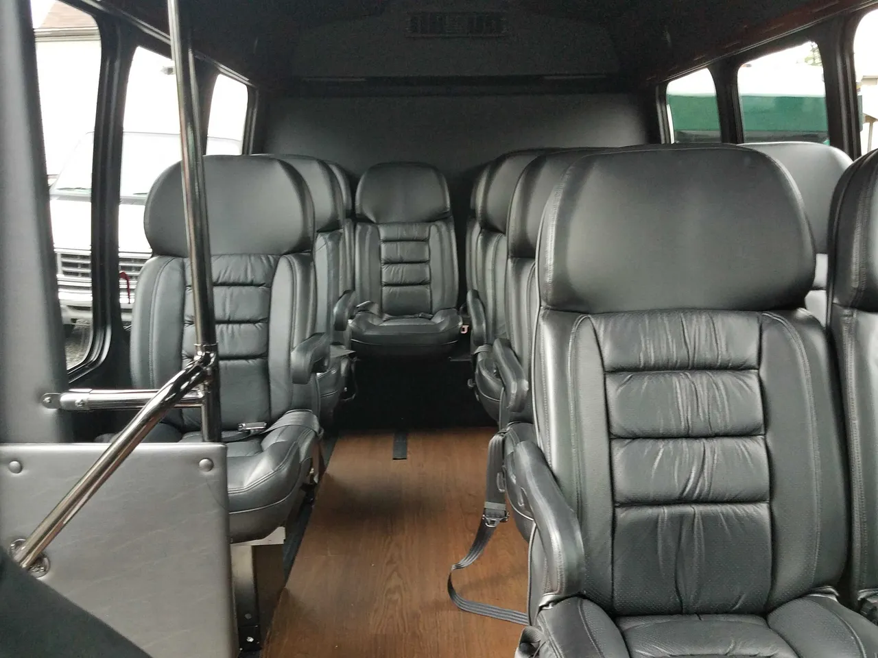 13 Passenger Mini Van 13 Passenger Mini Van interior with wood-look flooring and grab handles and rails for minibus rental