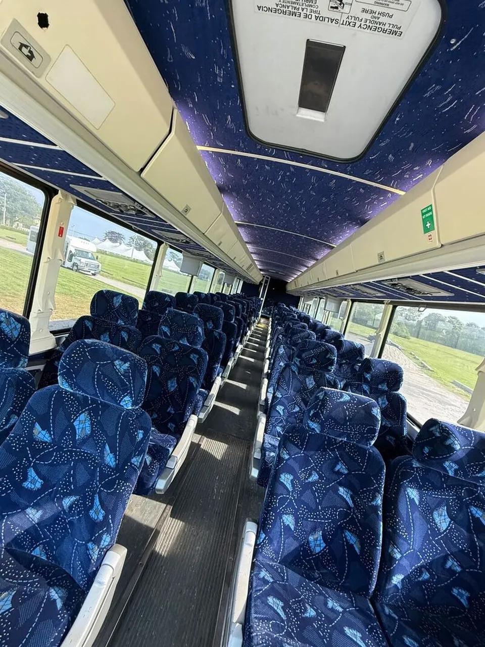 Motor Coach Luxury (Cloth Seats) interior with overhead parcel racks, photo 6 for charter bus rental