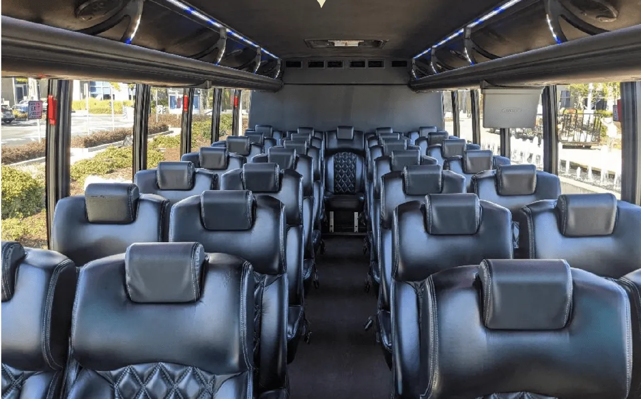Ford F550 Executive Mini Coach interior with LED accent lighting and overhead parcel racks for minibus rental