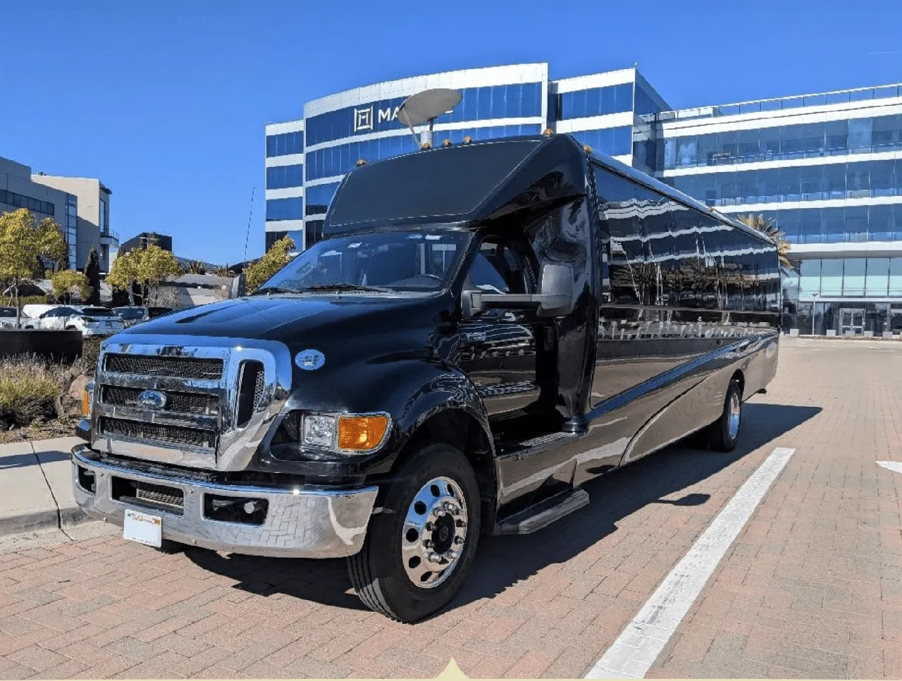Black Ford F550 Executive Mini Coach with tinted windows for minibus rental