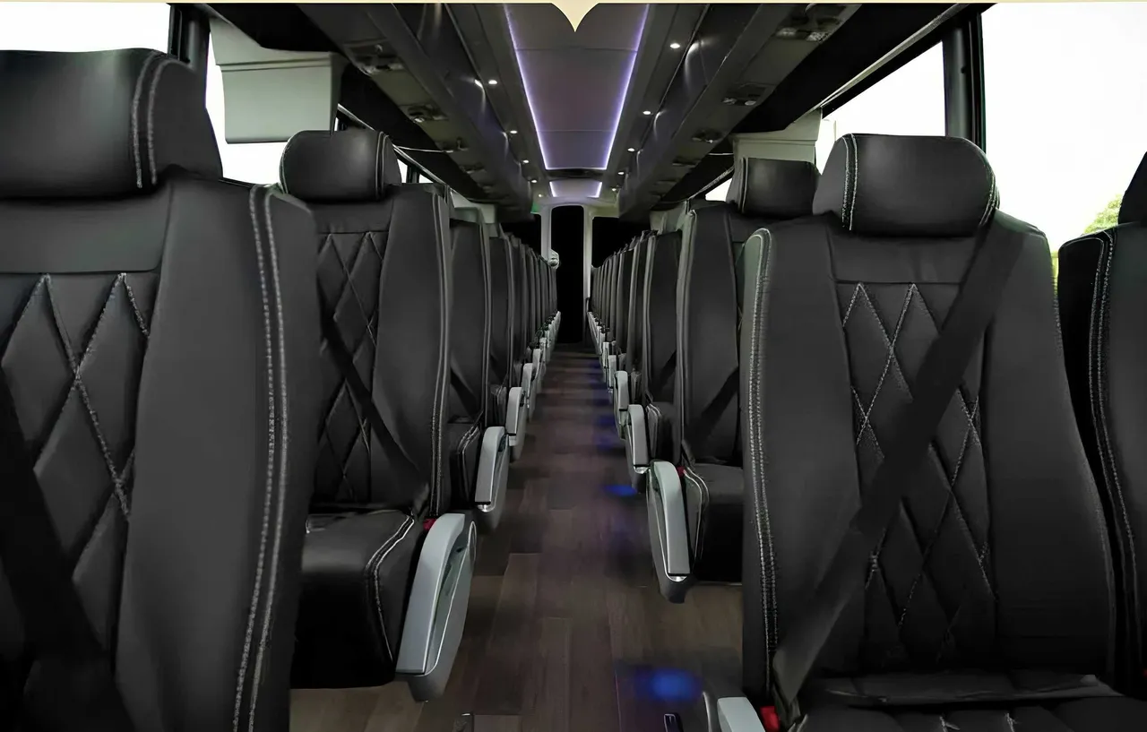 56 Passenger Motorcoach interior with LED accent lighting, LED ceiling lighting and passenger seat belts for charter bus rental
