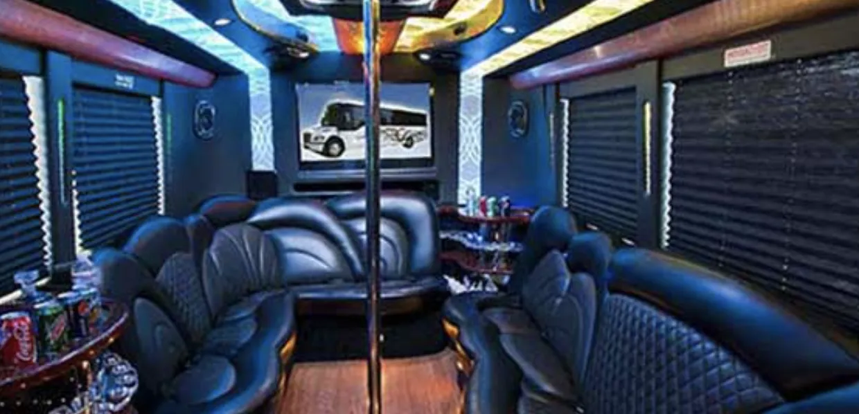 White 24 Passenger Party Bus 24 Passenger Party Bus interior with perimeter lounge seating, sofa-style seating and window shades for party bus rental