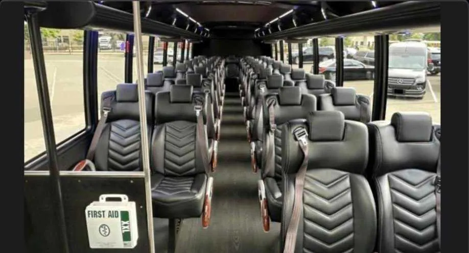 30 Passenger Shuttle Bus interior with LED ceiling lighting, passenger seat belts and overhead parcel racks for minibus rental