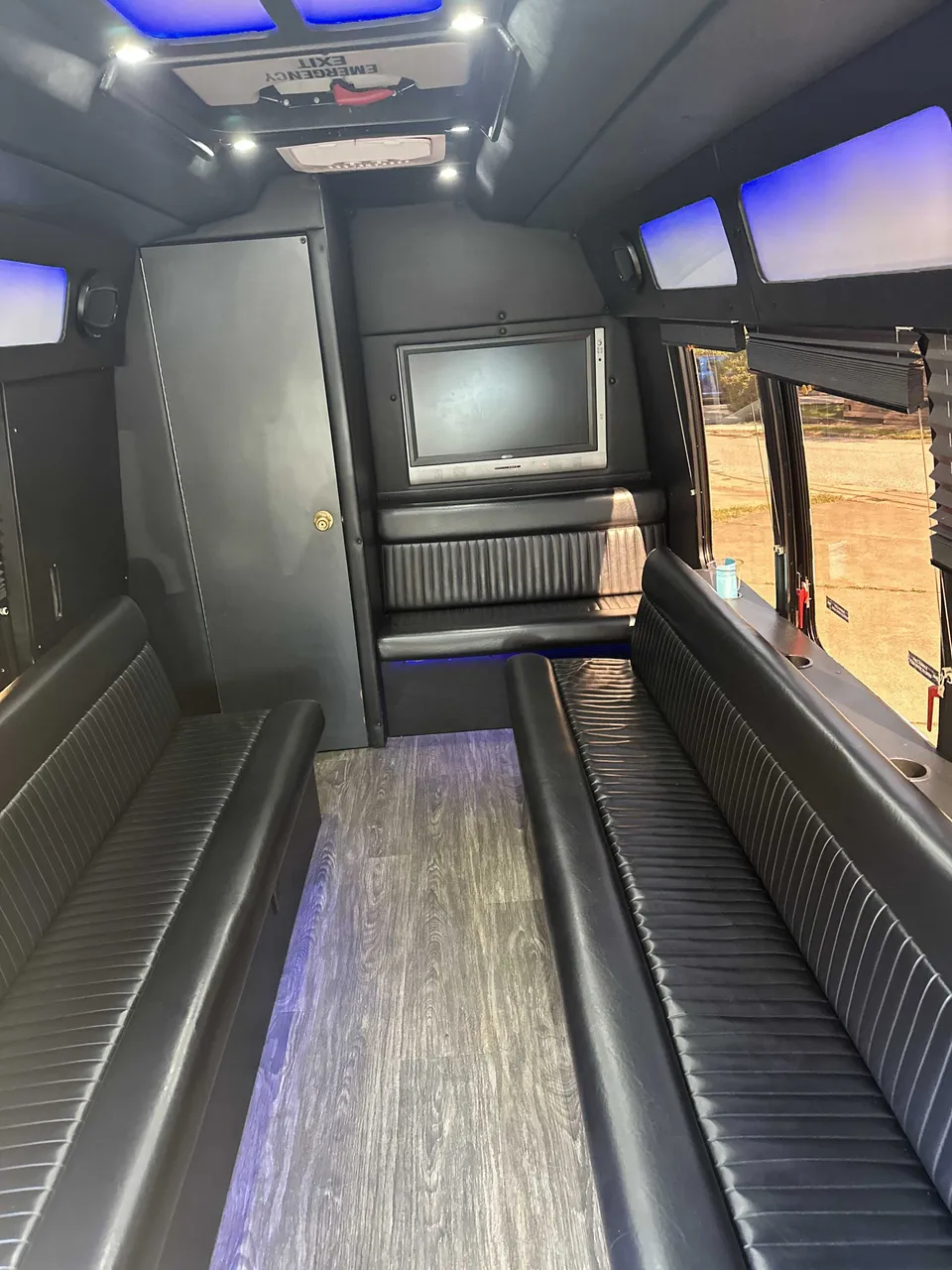 Small Party Bus interior with perimeter lounge seating, LED accent lighting and LED ceiling lighting for party bus rental