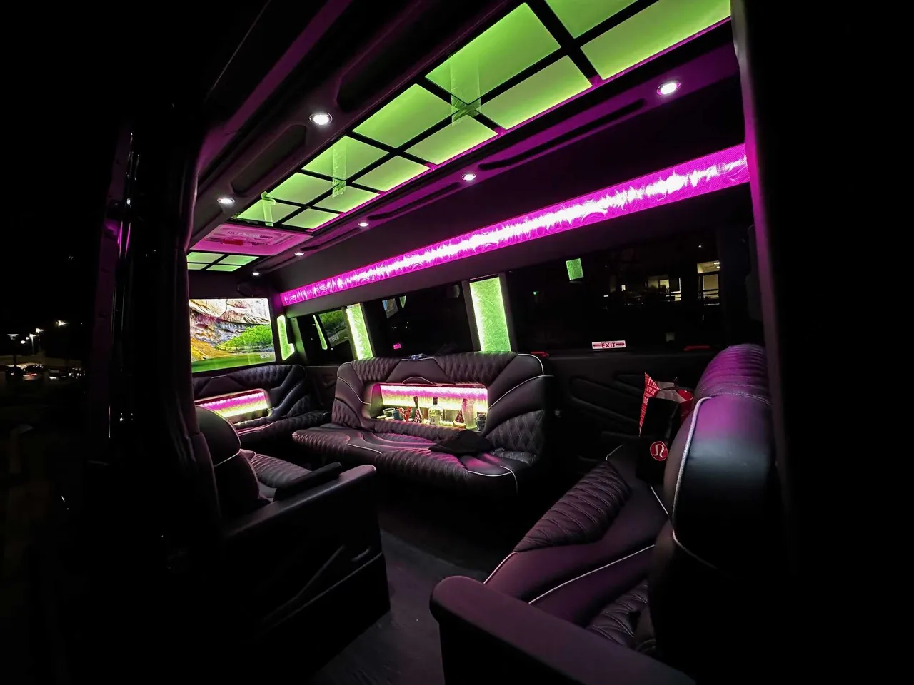 13 Passenger Sprinter Limousine interior with sofa-style seating, captain's chairs and LED accent lighting for party bus rental