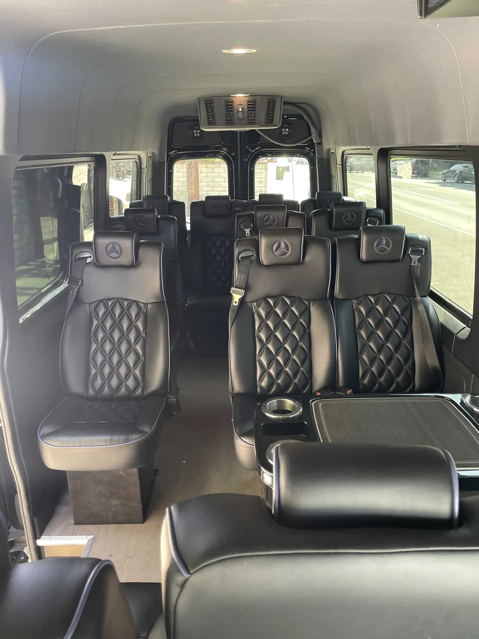 Sprinter Van interior with captain's chairs, passenger tables and cup holders for minibus rental
