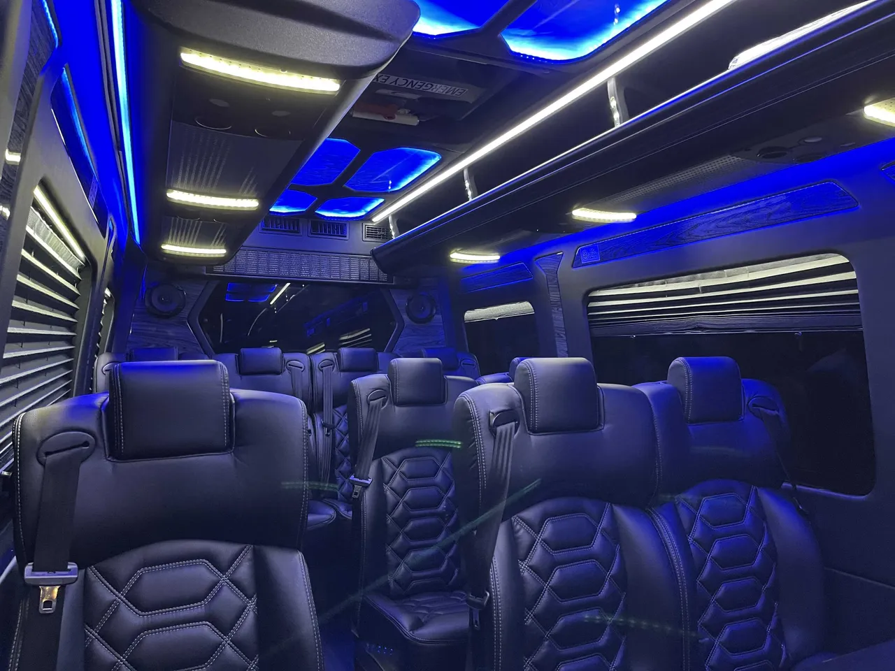 Sprinter VIP Van interior with captain's chairs, window shades and LED accent lighting for minibus rental