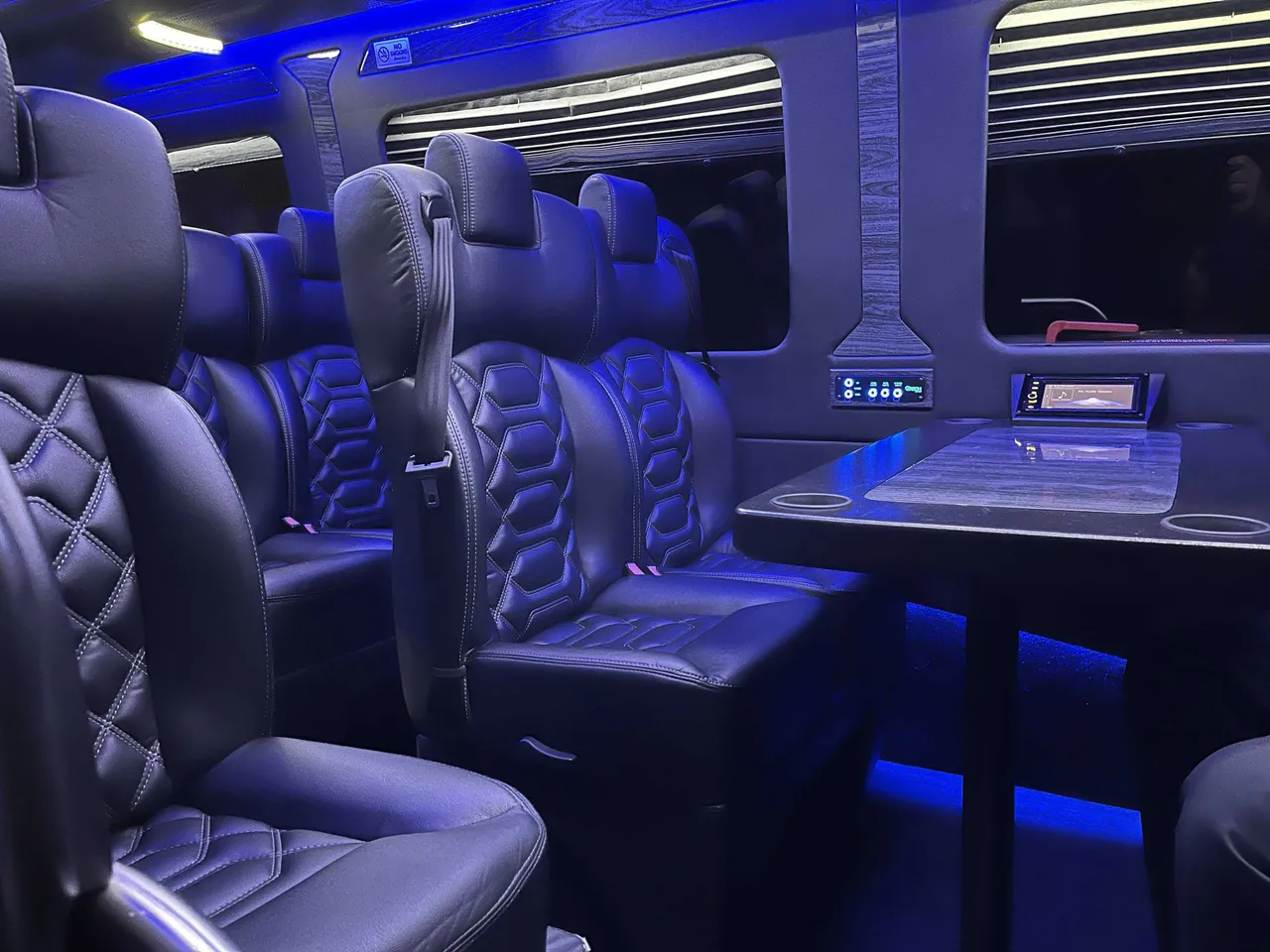 Sprinter VIP Van interior with captain's chairs, passenger tables and cup holders for minibus rental